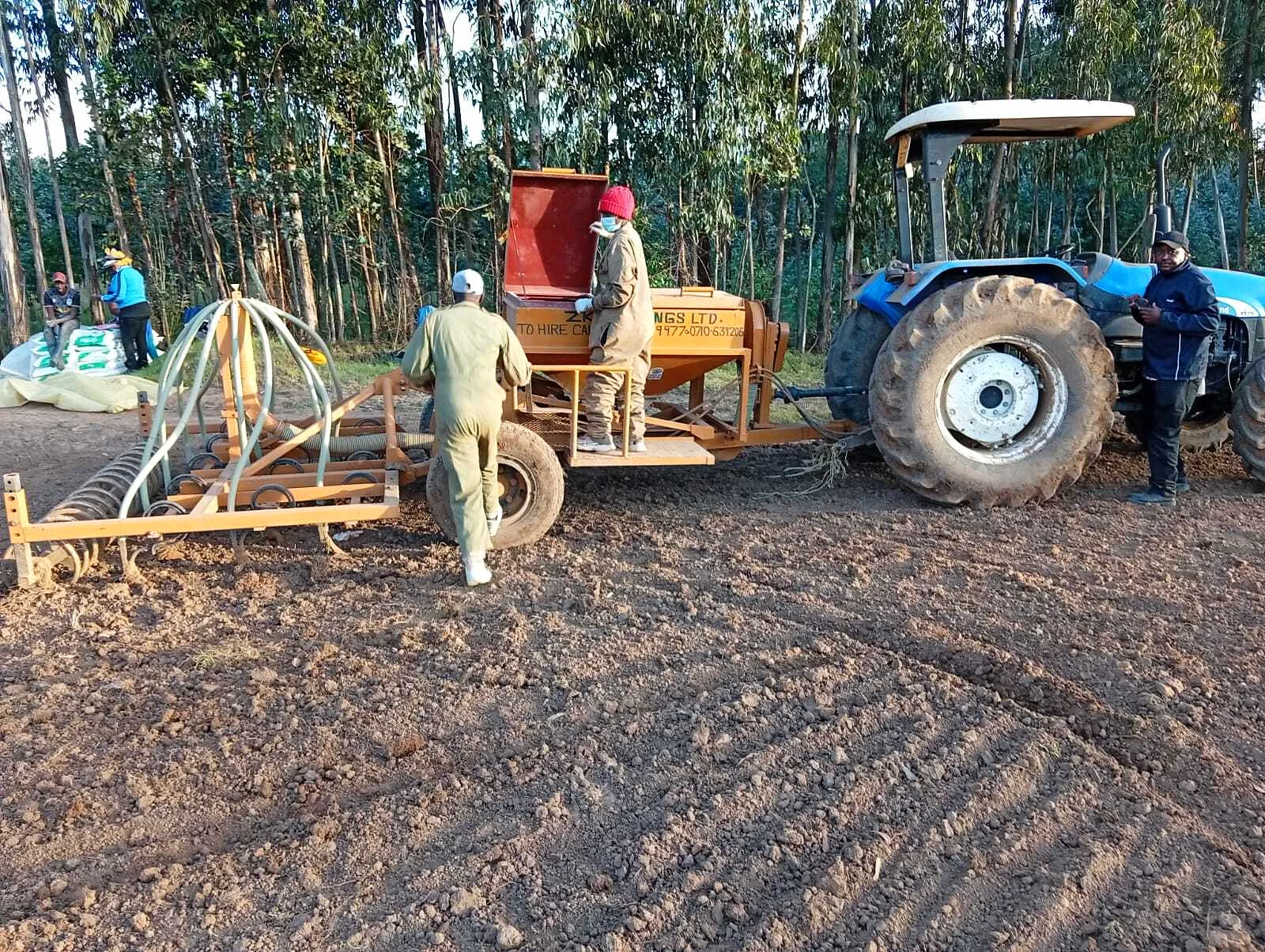 Tractor and seed drill preparing and planting a field in Kenya